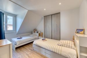 een slaapkamer met 2 bedden en een raam bij Les pieds dans l eau ! in Fécamp