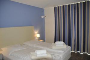 um quarto de hotel com duas camas e uma janela em Apartmenthaus Hafenspitze, Ap 29 "Heimathafen 29", Blickrichtung InnenstadtBinnenhafen - a72349 em Eckernförde