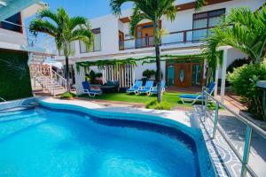 una piscina frente a una casa con palmeras en Blue Marlin Hotel, en Puerto Baquerizo Moreno