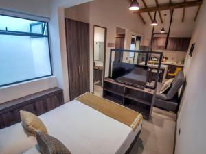 ein Wohnzimmer mit einem Bett, einem TV und einem Sofa in der Unterkunft Casa García Rent Home in Guatapé