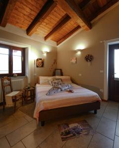 a bedroom with a large bed and a wooden ceiling at B&B Alla Borgata in Boves