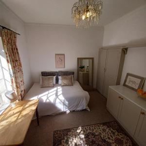 a bedroom with a bed and a chandelier at Craighall Park Stylish Garden Studio in Johannesburg