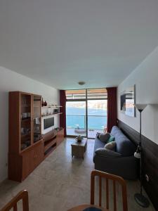 uma sala de estar com um sofá azul e uma televisão em Apartamento Paraiso Lido em Benidorm