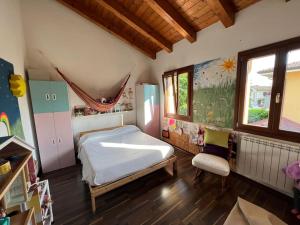 a bedroom with a bed and a chair in it at Suite familiare immersa nel verde in Bagnário Arsa