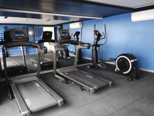 a gym with several tread machines in a room at Linda habitación baño privado en casa de familia desayuno incluido in Lima