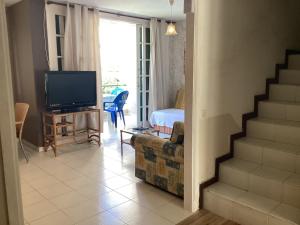 a living room with a staircase and a television at Las Viñas in Playa de las Americas