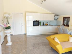 a living room with a yellow couch and a kitchen at Villa M & D in Sveti Filip i Jakov