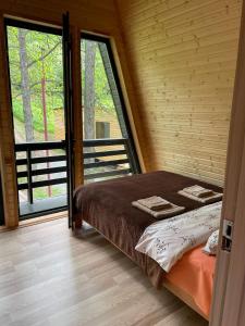 um quarto com uma cama e uma grande janela em Gurgeniani Twin Cottages em Lagodekhi