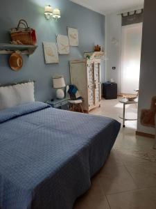 a bedroom with a bed with a blue comforter at Fattoria La Traccia in Fertilia