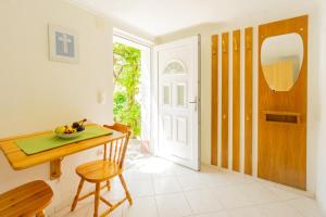ein Esszimmer mit einem Tisch, Stühlen und einer Tür in der Unterkunft Apartment Coral in Metajna