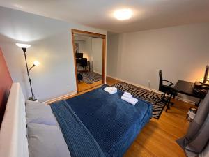 een slaapkamer met een bed met een blauwe deken bij Spacious private room near Finch station in Toronto