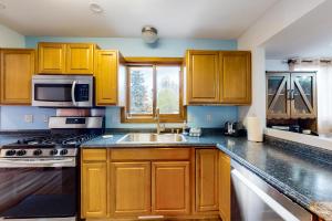 kuchnia z drewnianymi szafkami i zlewem w obiekcie South Side Escape w mieście Anchorage