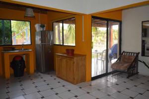 a kitchen with yellow walls and a refrigerator and a table at MALIBU HOUSE 