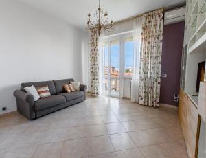 een woonkamer met een bank en een groot raam bij Luxury House near train station in Livorno