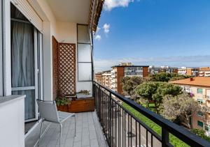 a balcony with a chair and a view of a city at Luxury House near train station in Livorno