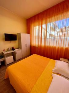 a bedroom with a large yellow bed and a window at Casa Zeffirino in Sanremo