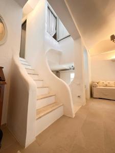 una scala bianca in una casa con finestra di Villa Sardinia Seaview&SPApool a Portu sa Ruxi