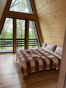 um quarto com uma cama num quarto com janelas grandes em Gurgeniani Twin Cottages em Lagodekhi