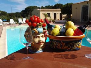 a table with wine glasses and a statue of a head at Locanda Rurale Santa Marta in Avola