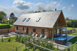 a large wooden house with a swimming pool in a yard at Holly Lodge in Welshpool