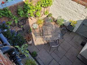 een patio met een tafel, stoelen en planten bij Hoylake 2 double bedrooms, continental breakfast included for the 151ist golf open at the Royal Liverpool in Hoylake