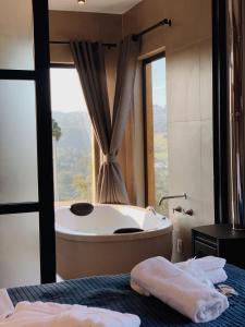 ein Badezimmer mit einer Badewanne und einem großen Fenster in der Unterkunft Cabanas Sunset View in Urubici