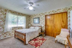 a bedroom with a bed and a chair and a window at Delaware Vacation Rental Walk to Lake Dardanelle! 