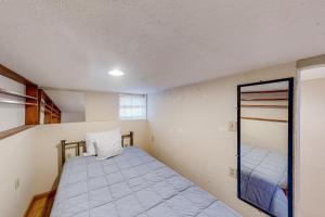 Dormitorio pequeño con cama y espejo en Cozy Corner by the Bay, en Reedsport