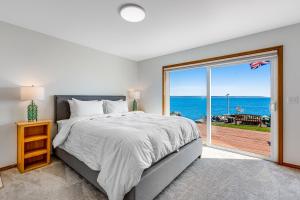 - une chambre avec un lit et une vue sur l'océan dans l'établissement Scatchet Head Beach House, à Clinton