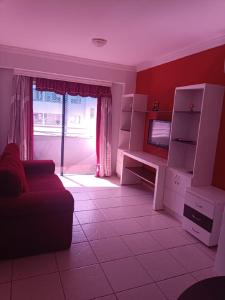 een woonkamer met een bank en een televisie bij Apart Flat Aguas da Serra in Rio Quente