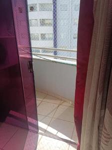 een badkamer met een glazen deur en een raam bij Apart Flat Aguas da Serra in Rio Quente