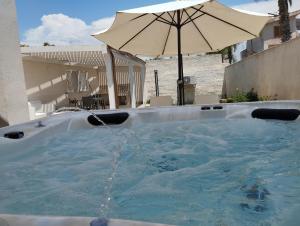 馬爾薩拉的住宿－Signorino Eco Resort & Spa，前面设有带遮阳伞的按摩浴缸。