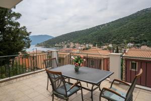 een tafel en stoelen op een balkon met uitzicht bij Faos Luxury Apartments in Ayia Evfimia