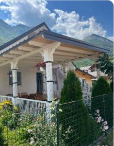 a white house with a large pergola at Lola Guest House in Vusanje