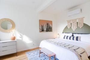 a bedroom with a white bed and a mirror at 1 Bedroom Casita - Casa Blanca in Montecito