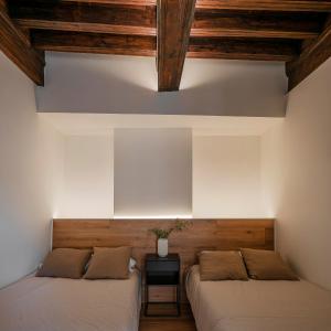 two beds in a room with wooden ceilings at El Jardinillo del Salvador in Cuenca