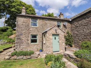 a stone house with a green door at White House in Penrith