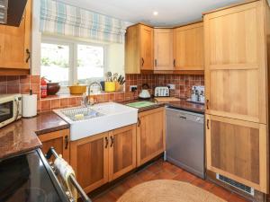 a kitchen with wooden cabinets and a sink and a dishwasher at White House in Penrith