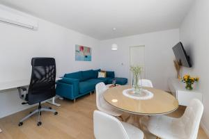 a living room with a table and a blue couch at LuSea Apartment in Zadar