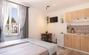 a small bedroom with a bed and a kitchen at Apartma Mimi in Izola