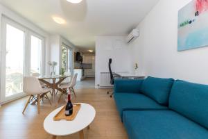 a living room with a blue couch and a table at LuSea Apartment in Zadar
