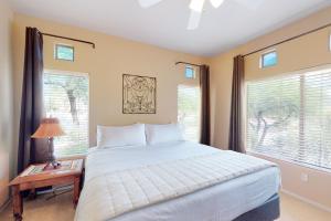 une chambre avec un lit, une table et des fenêtres dans l'établissement Vistoso Resort Casita #143, à Oro Valley 20 autres photos