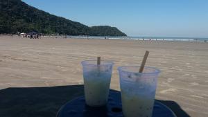two plastic cups sitting on a tray on the beach at Praia Grande, Canto do Forte, Apto ,2 noites seguidas , apenas 2 diárias com Wi-Fi in Praia Grande