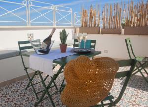 a table with a bottle of wine and a chair at NEREA - Apulian Suite and Rooms in Monopoli