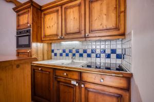uma cozinha com armários de madeira e um lavatório em Appartments in Tignes Ecrin des Neiges em Tignes