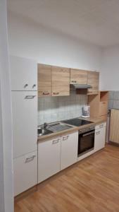 a kitchen with white cabinets and a sink at Premier Triple room MZ in Vienna
