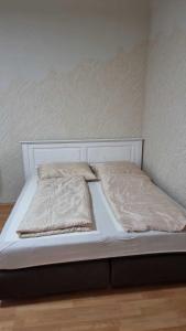 a white bed with two pillows on top of it at Premier Triple room MZ in Vienna