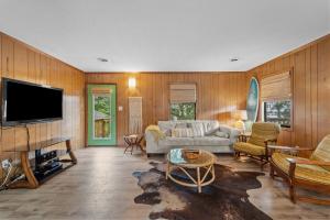 a living room with a couch and a tv at Sunny Daze KDH by Village Reality in Kill Devil Hills