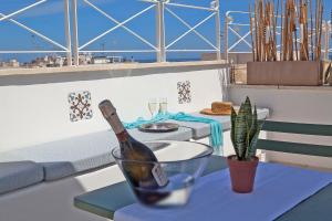 a bottle of wine sitting on a table with a plant at NEREA - Apulian Suite and Rooms in Monopoli