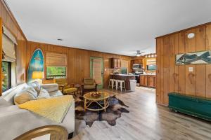 a living room with a couch and a surfboard on the wall at Sunny Daze KDH by Village Reality in Kill Devil Hills